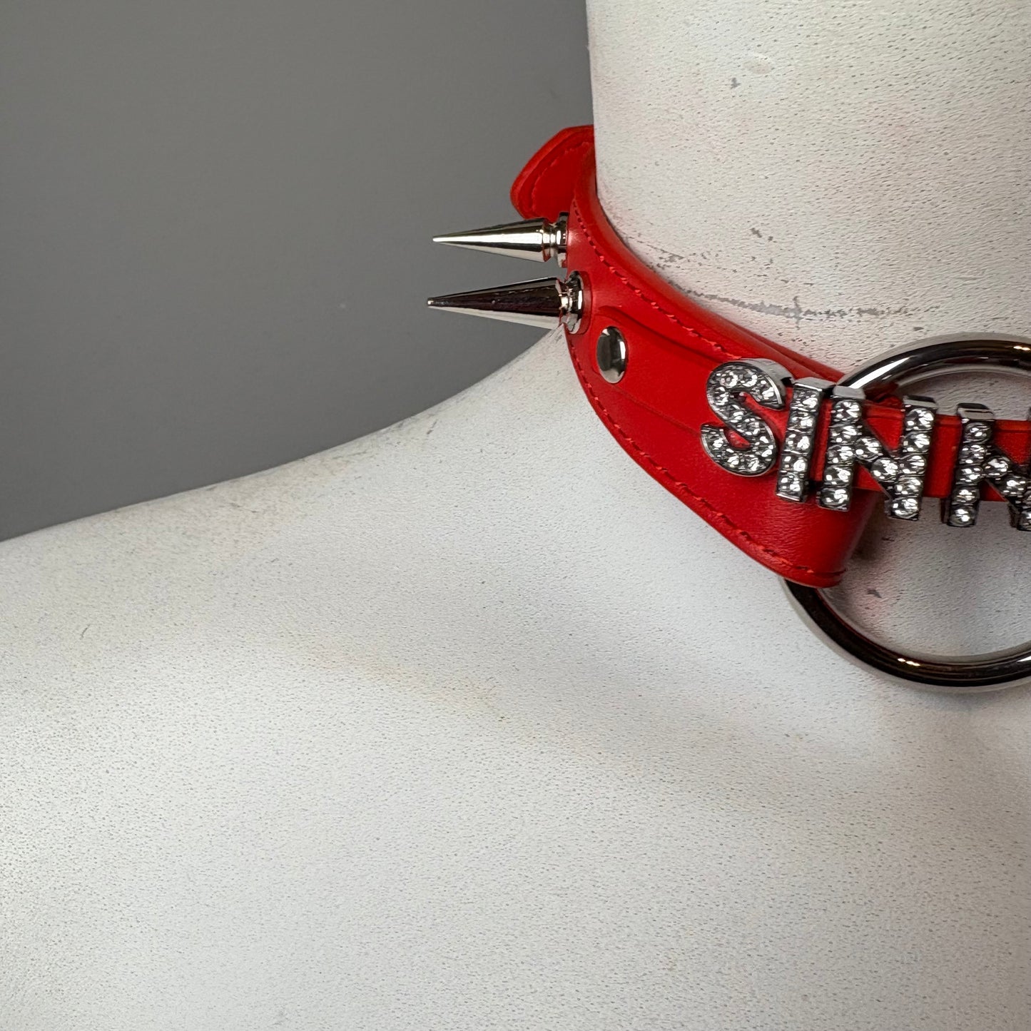 Chocker rosso con scritta “sinner”