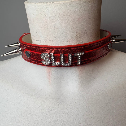 Chocker rosso brillantato con scritta “slut”