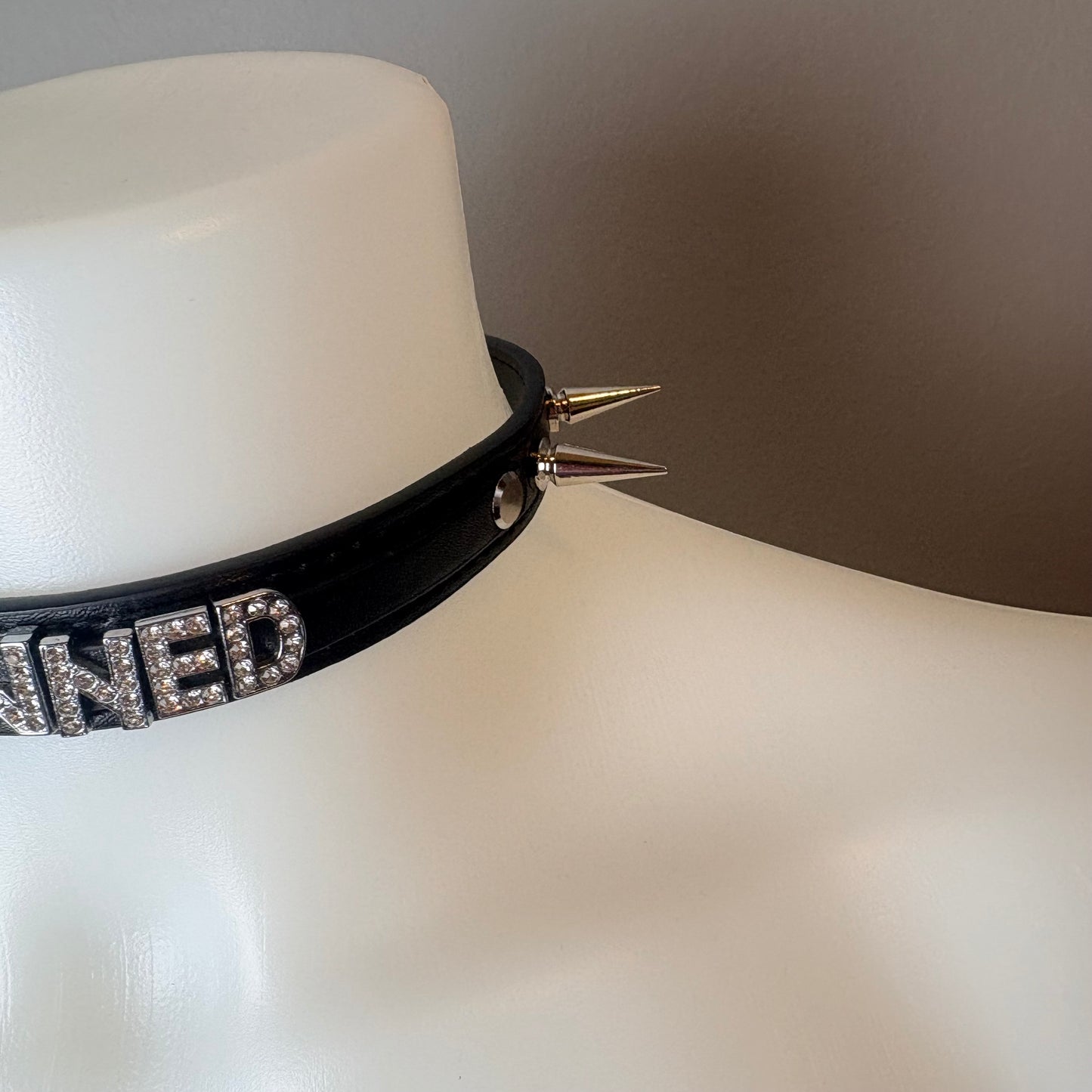 Chocker nero con scritta “owned”